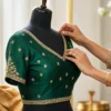 Tailor fitting an emerald blouse neckline on a dress form