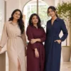Three women wearing beige, wine and navy shirt dresses