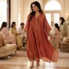 Woman wearing a rust kaftan at a festive family gathering