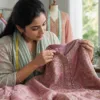 Boutique tailor inspecting seams, buttons and floral embroidery