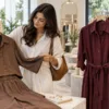 Woman examining a cocoa co-ord set while comparing boutique outfits