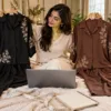 Woman comparing black and cocoa embroidered co-ord sets online