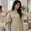 Tailor checking sleeve and shoulder movement during a women’s fitting