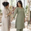 Female tailor recording shoulder and sleeve fit for a green kurta