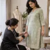 Tailor pinning a kurta side seam during an alteration fitting